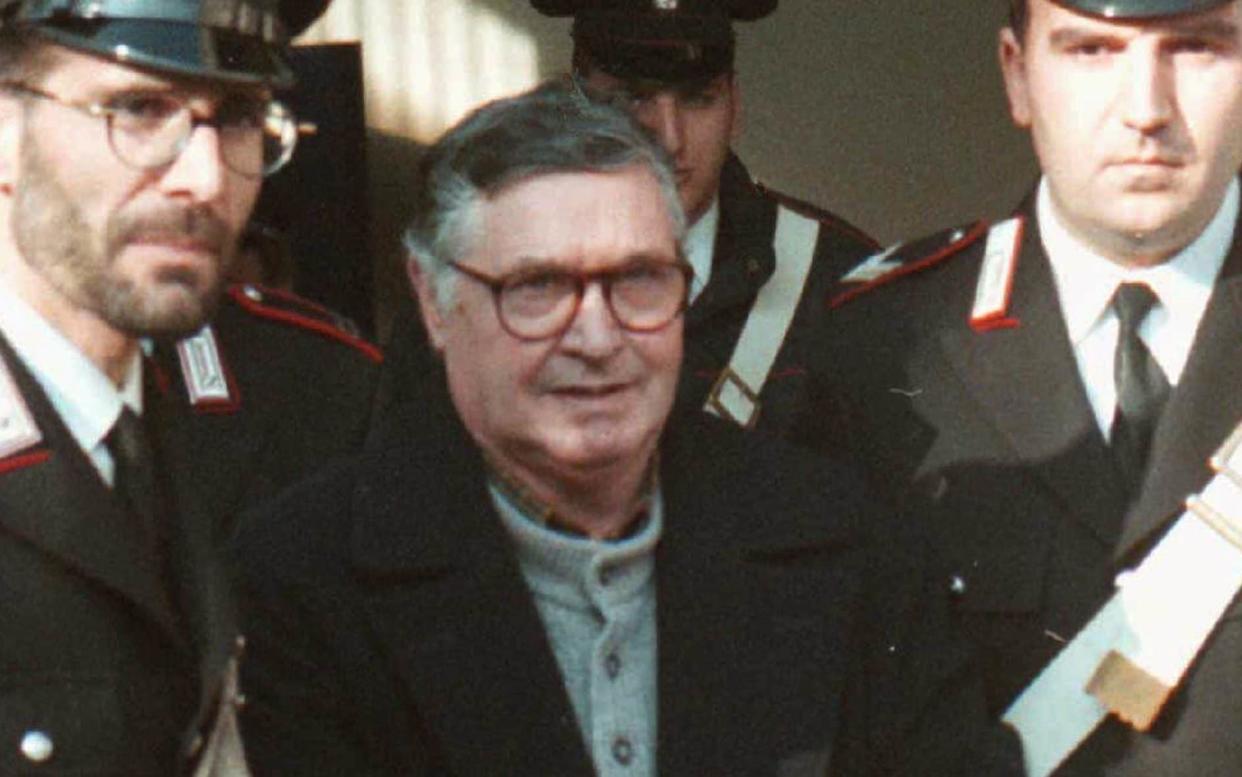 Mafia ''boss of bosses'' Salvatore ''Toto'' Riina, center, enters handcuffed into Bologna's bunker-courtroom, escorted by Carabinieri, Italian paramiliary police, in Bologna, Italy, 1996 - AP