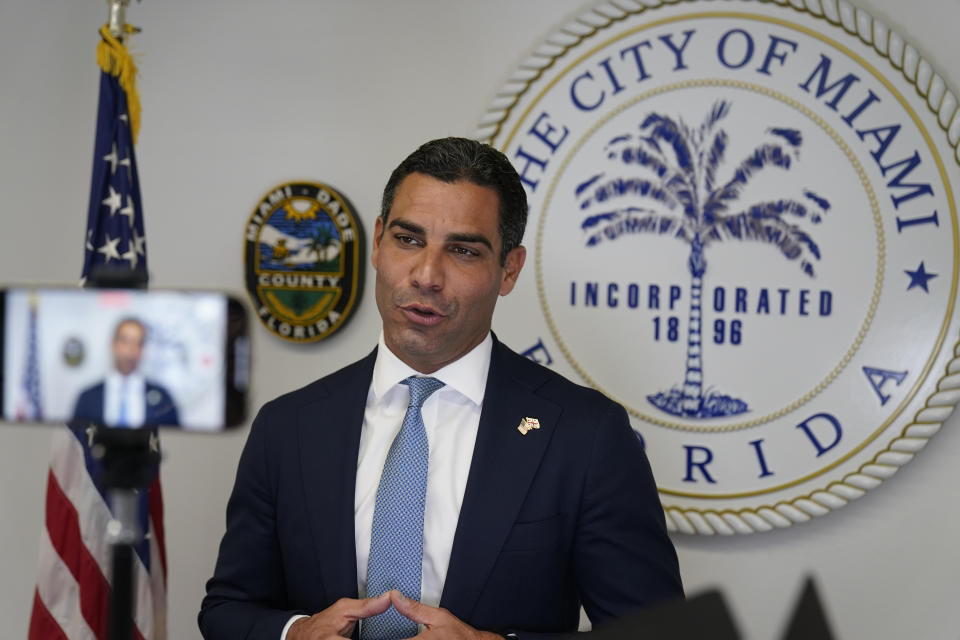 Miami Mayor Francis Suarez, right, records a video in his office, Friday, Oct. 29, 2021, at City Hall in Miami. Suarez is hoping to easily secure a second term on Tuesday, Nov 2, 2021. His reelection campaign has offered an opportunity to show he can raise millions as he seeks to elevate his profile at a national level. (AP Photo/Wilfredo Lee)