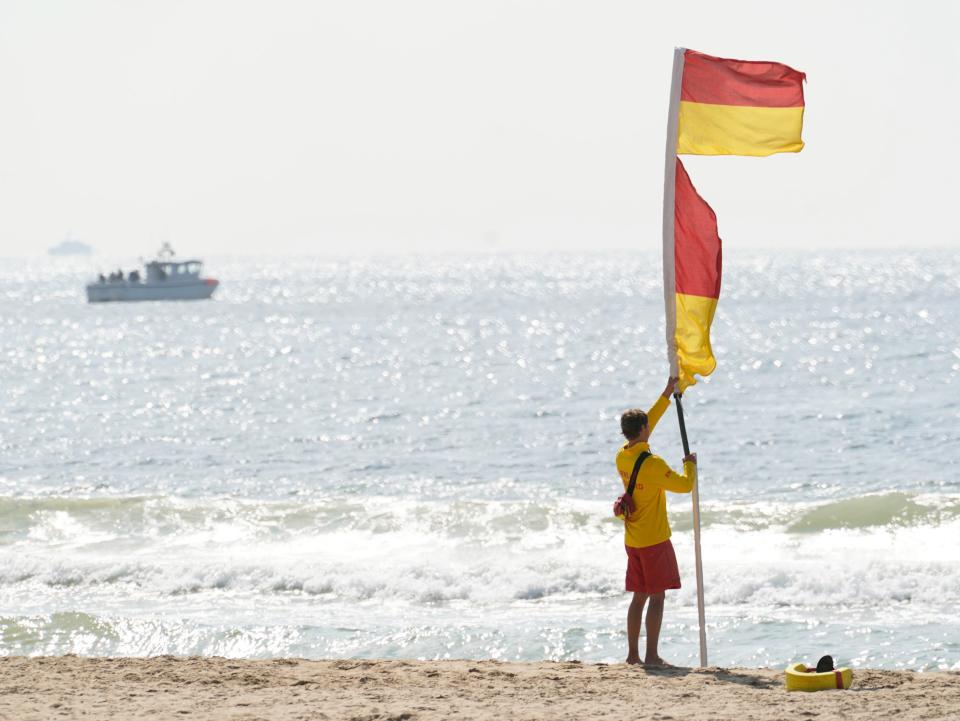 RNLI lifeguards put up flags on the beach (PA)