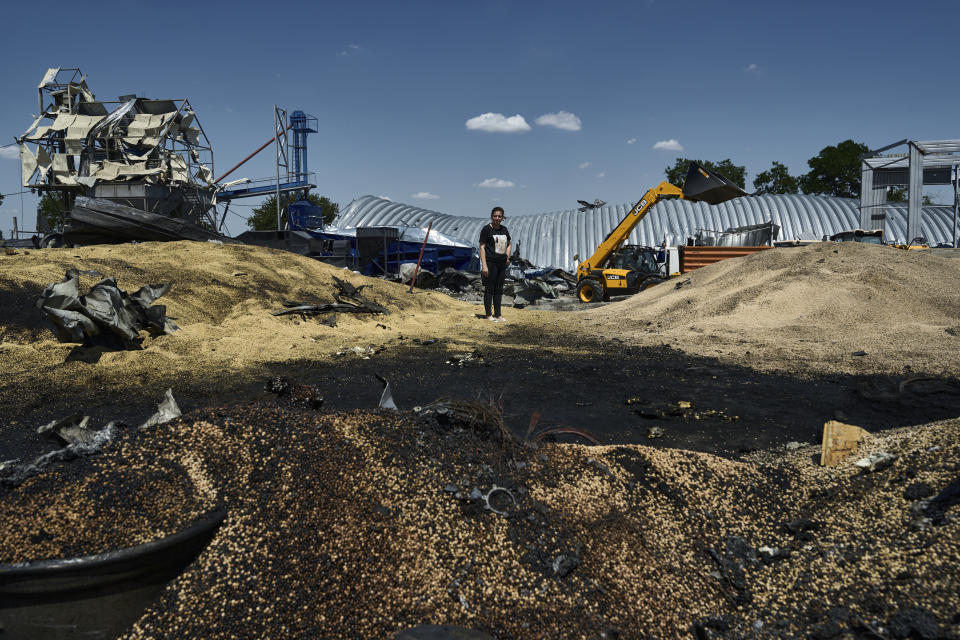 FILE - Olha stands among debris of a farm storage building destroyed during a Russian attack in Odesa region, Ukraine, on July 21, 2023. Russia has repeatedly fired missiles and drones at Ukrainian ports key to sending grain to the world. Moscow has declared large swaths of the Black Sea dangerous for shipping. (AP Photo/Libkos, File)