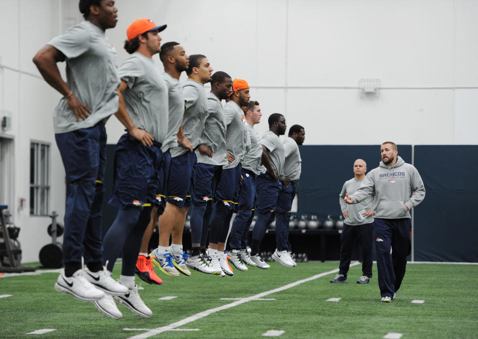 This photo provided by the Denver Broncos shows Strength and Conditioning coach Luke Richesson, right, working with players during an offseason traiing session at the NFL football teams training facility in Englewood, Colo., on Monday, April 21, 2014. (AP Photo/Denver Broncos, Eric Lars Bakke)