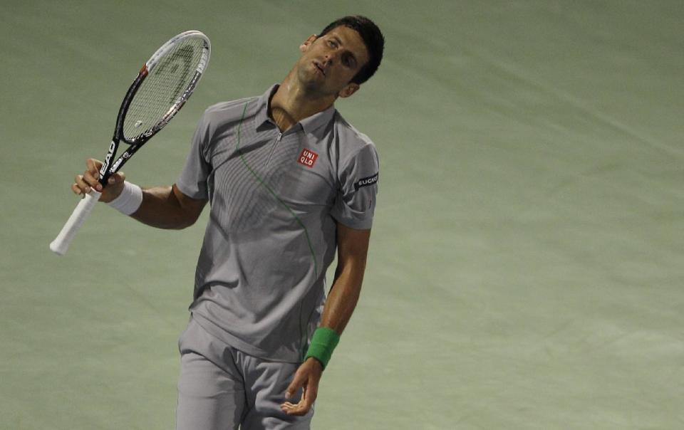 Novak Djokovic of Serbia reacts after he missed a ball against Roger Federer of Switzerland during a semi final match of the Dubai Tennis Championships in Dubai, United Arab Emirates, Friday, Feb. 28, 2014. (AP Photo/Kamran Jebreili)