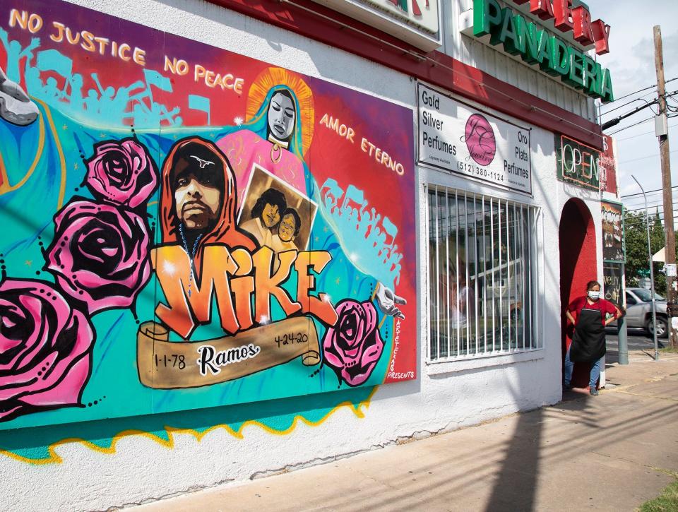 A woman stands outside of La Mexicana Bakery looking at a mural of Mike Ramos on July 28, 2020.
