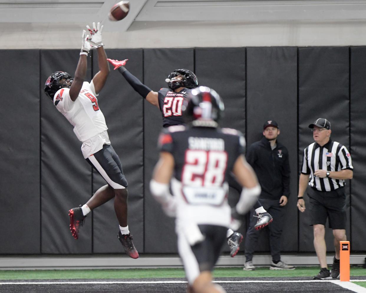 Texas Tech tight end Johncarlos Miller (9) goes up to catch a touchdown pass from Will Hammond in the first half of the spring game Saturday at the Sports Performance Center. Defending on the play is safety Marcus Ramon-Edwards (20).