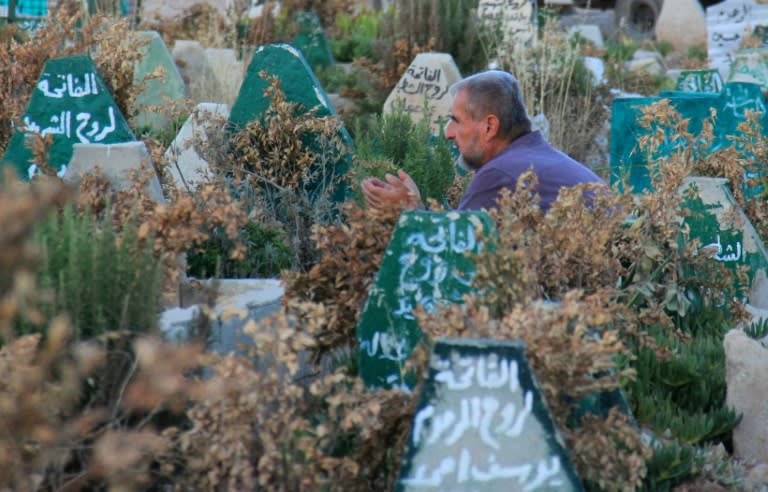 A Syrian man prays last July at a cemetery in Khan Sheikhun, 100 days after a suspected toxic gas attack killed some 88 people, including 31 children