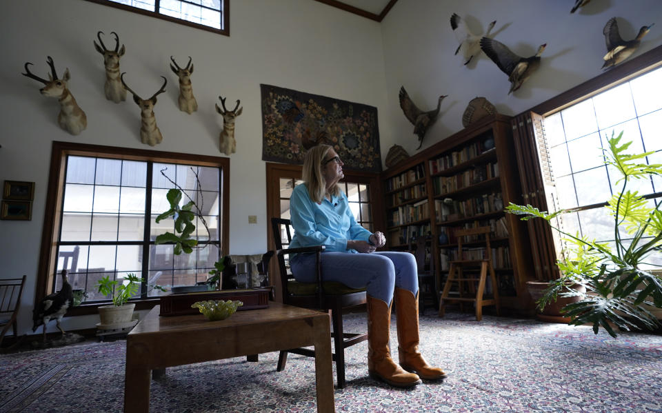 Alice Ball Strunk, president of the Devils River Conservancy, sits in a room decorated with hunting trophies at her home, Thursday, Feb. 16, 2023, near Del Rio, Texas. Strunk's property is adjacent to a proposed wind development. (AP Photo/Eric Gay)
