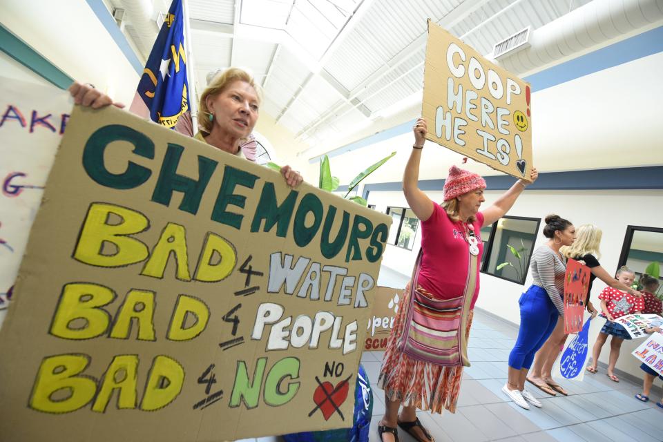 Residents hold up signs when Gov. Roy Cooper visited Wilmington in 2017 -- nearly seven weeks after the GenX water crisis came to light.