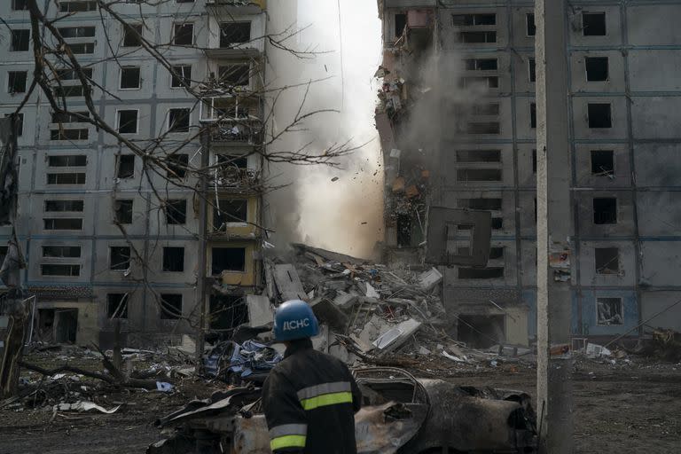 Un bombero observa cómo se derrumba parte de un muro de un edificio residencial que quedó muy dañado tras un ataque ruso en Zaporiyia, Ucrania, el 9 de octubre de 2022.