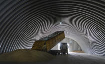 FILE - A dump track unloads grain in a granary in the village of Zghurivka, Ukraine, Tuesday, Aug. 9, 2022. A ship approached Ukraine on Friday, Aug. 12, 2022, to pick up wheat for hungry people in Ethiopia, in the first food delivery to Africa under a U.N.-brokered plan to unblock grain trapped by Russia’s war and bring relief to some of the millions worldwide on the brink of starvation. (AP Photo/Efrem Lukatsky, File)