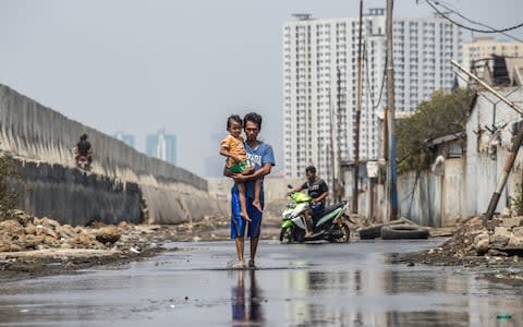 Dodi Riyanto, with his daughter Ulfi, has spotted cracks in the sea wall - Credit: Graham Crouch