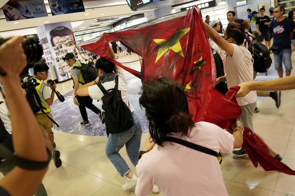 Anti-government protesters destroy a Chinese flag in the New Town Plaza at Sha Tin. (REUTERS)