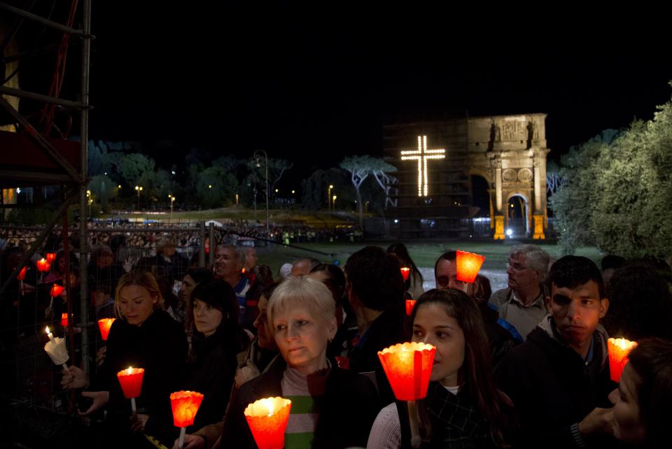 Faithful attend the Via Crucis (Way of the Cross) torchlight procession celebrated by Pope Francis in front of the Colosseum on Good Friday in Rome, Friday, April 18, 2014. (AP Photo/Gregorio Borgia)