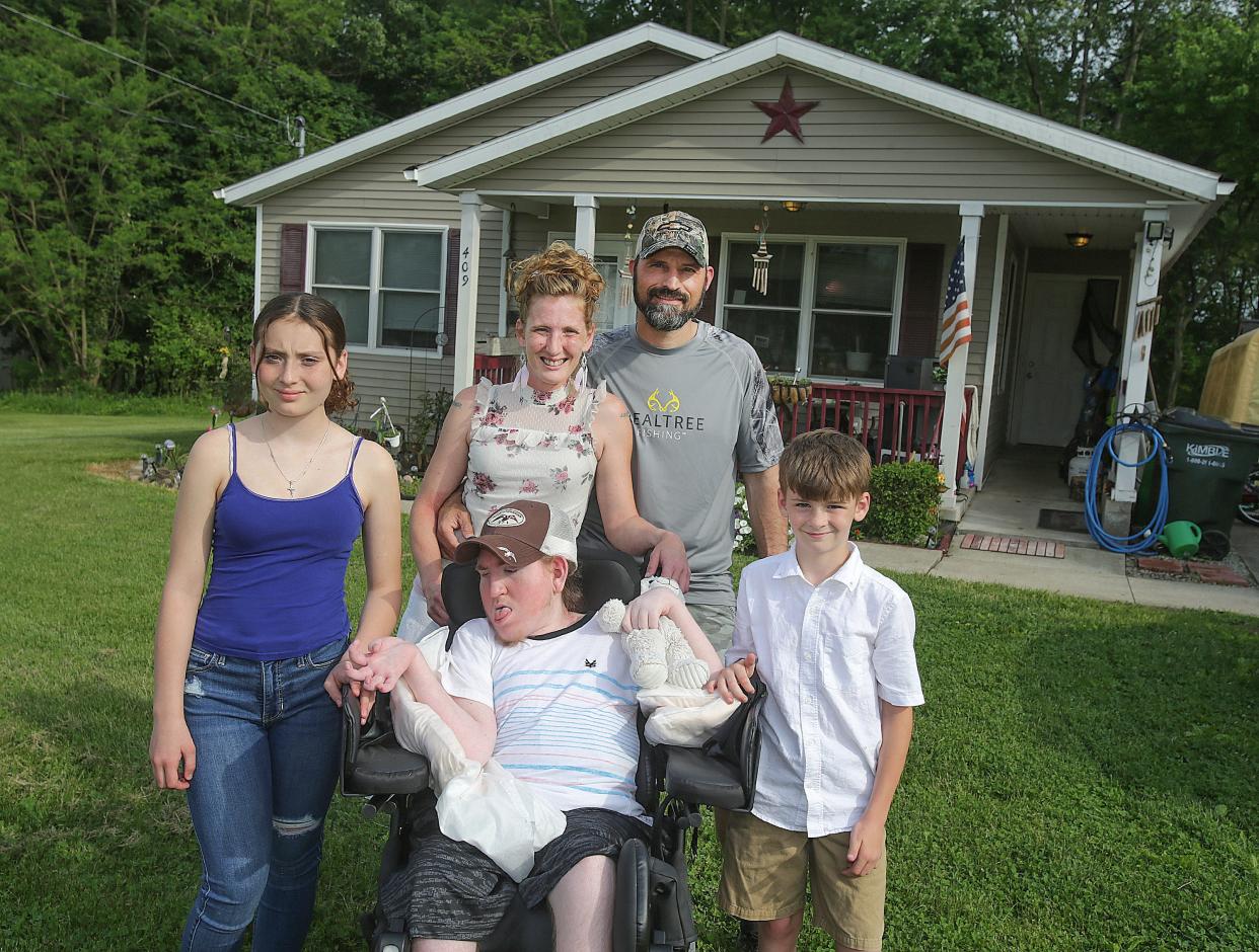 Amanda Martin and her children (from left) Savannah Martin, 14, Joseph Martin, 21, and Dylan Martin, 8, along with her boyfriend, Andy Eberhardt, stand in the front of their McKinley Avenue SW home. IMPACT Massillon is set to help expand the family's driveway on June 4 as part of the group's annual day of service that helps transform an area of town.