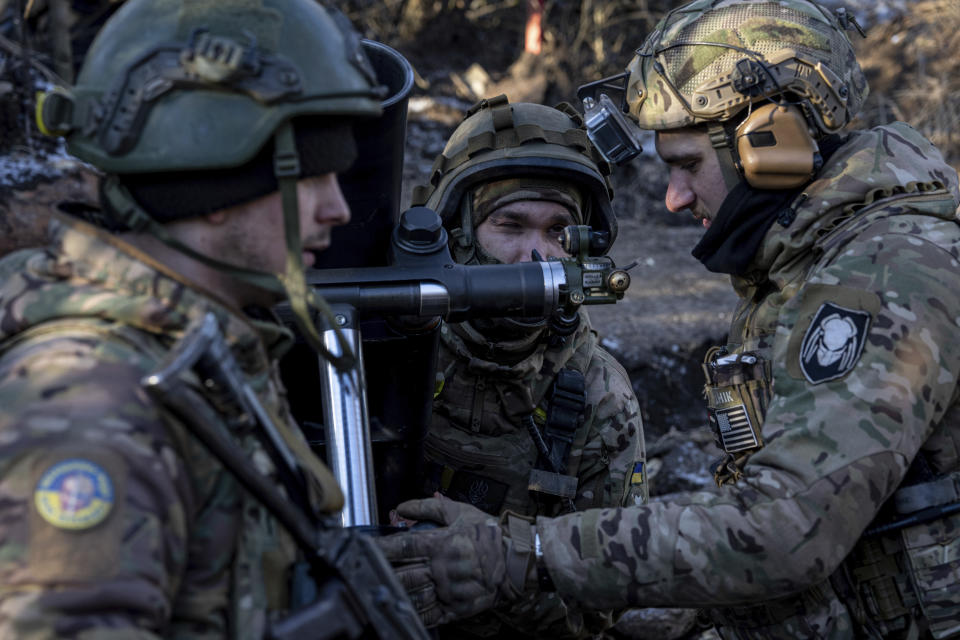 Ukrainian servicemen prepare to fire a 120 mm mortar towards Russian positions at the frontline near Bakhmut, Donetsk region, Ukraine, Wednesday, Jan. 11, 2023. (AP Photo/Evgeniy Maloletka)