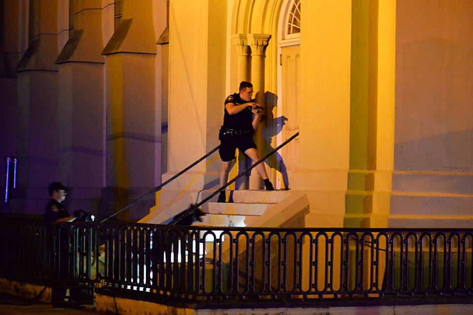 Charleston police officers search for a shooting suspect outside the Emanuel AME Church.