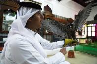 Qatari Abdulaziz Alansi, 16, speaks to his brother as he holds a falcon for sale in a shop in Doha, Qatar, Saturday, Nov. 19, 2022. Qatar has become synonymous with soccer since winning the rights to host the FIFA World Cup that opens on Sunday. But another sport is flying high in the historic center of Doha as over a million foreign fans flock to the tiny emirate: Falconry. (AP Photo/Jon Gambrell)