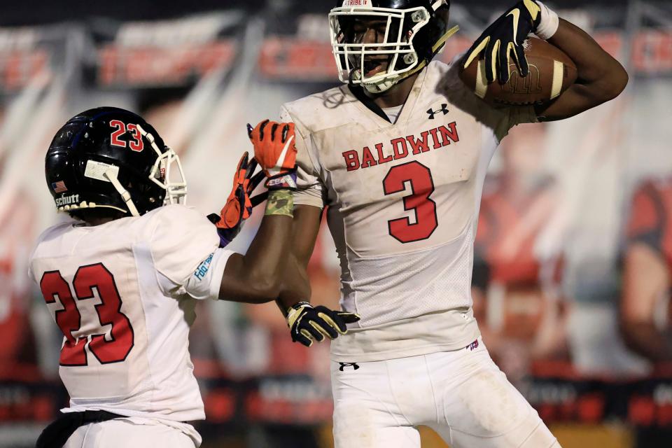 Baldwin's Mason Carter (3) celebrates his touchdown score with Tyler Moore (23) against Baker County on Nov. 10.