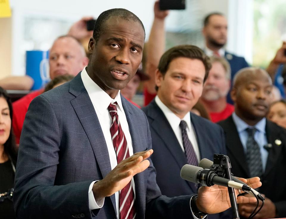 Florida Surgeon General Dr. Joseph Ladapo, front left, gestures as speaks to supporters and members of the media before a bill signing by Gov. Ron DeSantis, front right, Nov. 18, in Brandon, Fla.