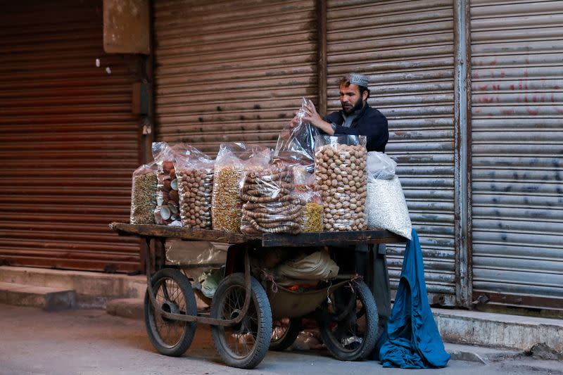 A man arranges bags of dry fruits while selling them from a pushcart early morning at a market in Karachi