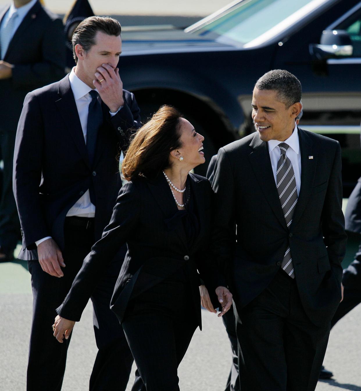 President Barack Obama walks with California Attorney General Kamala Harris, center, and  California Lt. Gov. Gavin Newsom, after arriving at San Francisco International Airport in San Francisco, on Feb. 16, 2012.