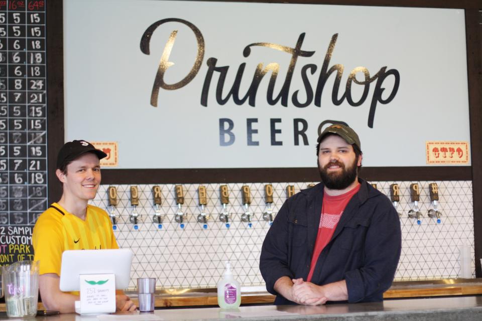 Mac Bower sells to-go beer at Printshop Beer Co on March 21. Pictured here with owner/brewer Peter Riesing. March 2020