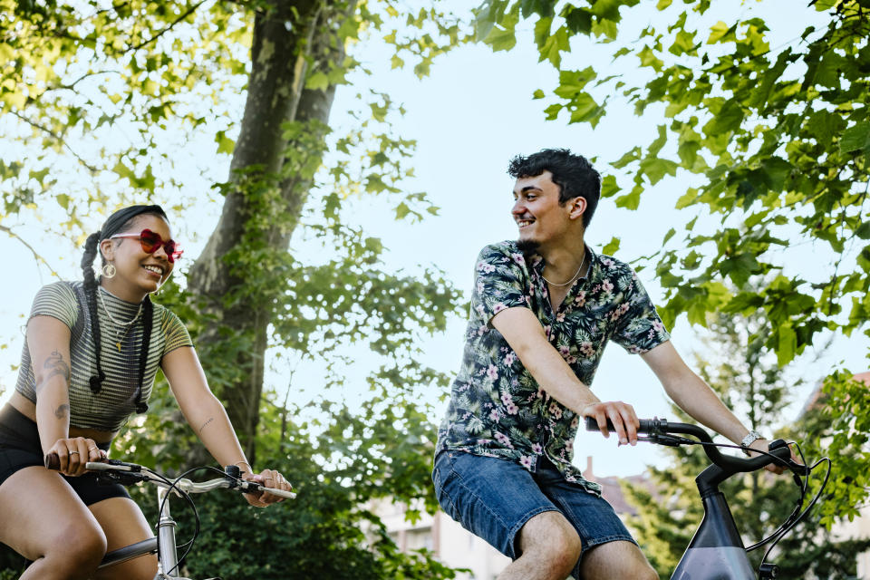 Couple riding a bike together in the summer. (Getty Images)