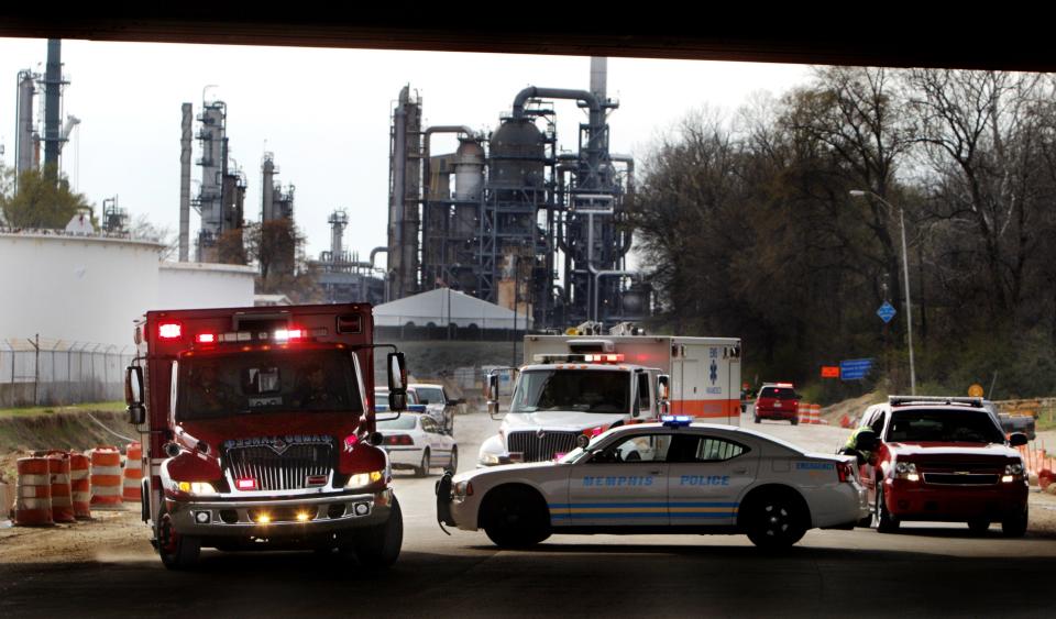 A pair of ambulances pull out of the Valero oil refinery after an explosion at the plant that critically injured three people in March 2012.