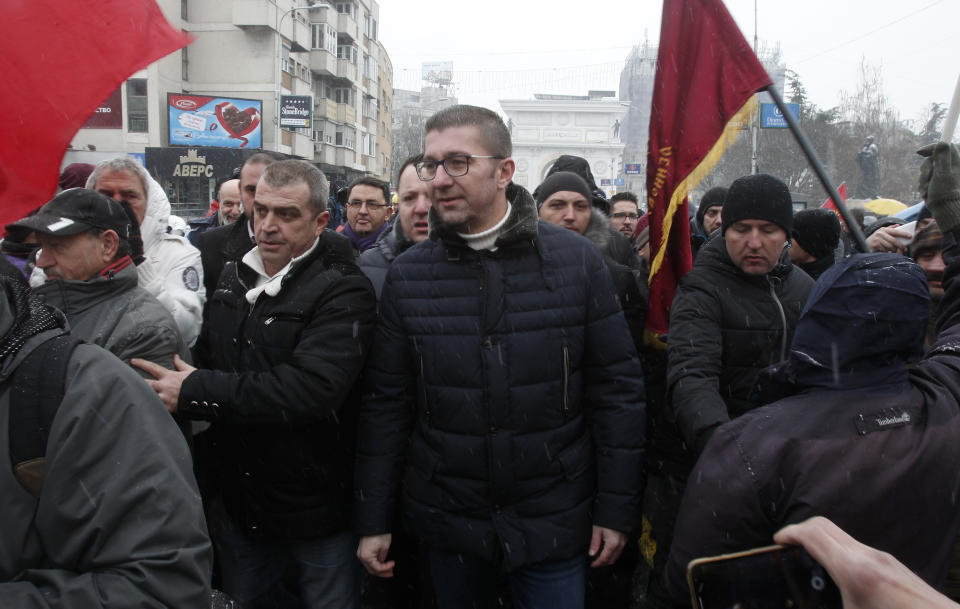 Hristijan Mickoski, center, leader of the opposition VMRO-DPMNE party, joins the opponents to the change of the country's constitutional name on a protest outside the parliament building prior to a session of the Macedonian Parliament in the capital Skopje, Wednesday, Jan. 9, 2019. Macedonian lawmakers are entering the last phase of debate on constitutional changes to rename the country North Macedonia as part of the deal with neighboring Greece to pave the way for NATO membership and eventually European Union. (AP Photo/Boris Grdanoski)