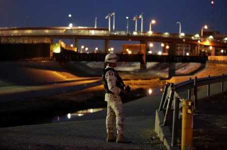 A member of the Mexican National Guard stands guard near the border between Mexico and U.S.