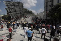 <p>Rescue workers and volunteers search a building that collapsed after an earthquake in the Roma neighborhood of Mexico City, Tuesday, Sept. 19, 2017. A powerful earthquake jolted central Mexico on Tuesday, causing buildings to sway sickeningly in the capital on the anniversary of a 1985 quake that did major damage. (AP Photo/Eduardo Verdugo) </p>