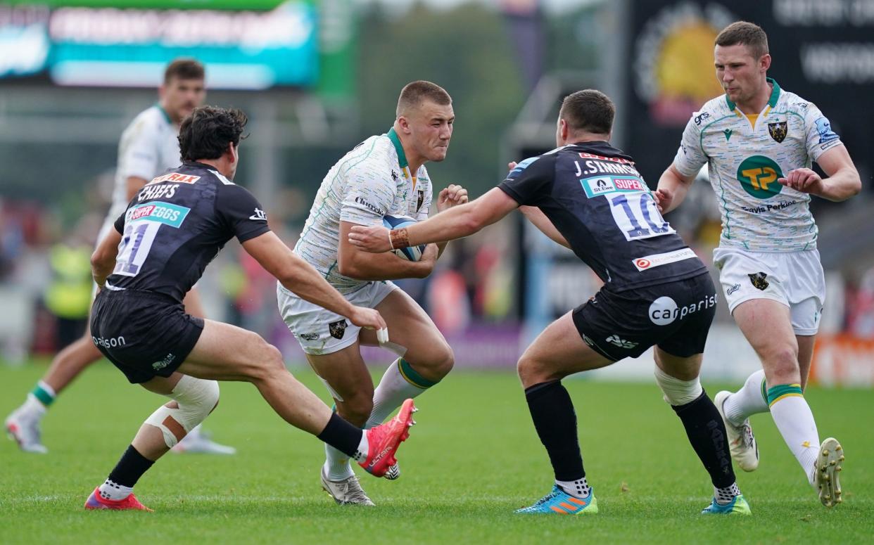 Northampton's Ollie Sleightholme (centre) is tackled by Exeter Chiefs Joe Simmonds (centre right) and Sam Hidalgo-Clyne (left) during the Gallagher Premiership match at Sandy Park, Exeter. - PA
