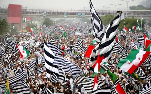 A sea of black and white flags representing the JUI-F party - Credit: SOHAIL SHAHZAD/EPA-EFE/REX