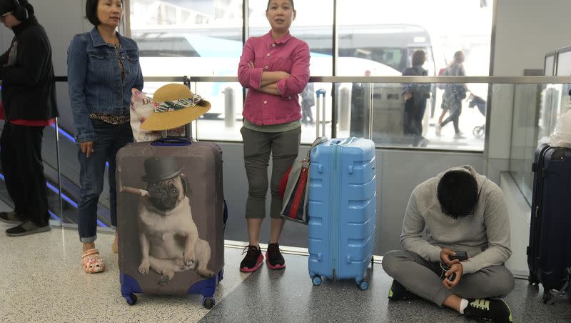 Travelers from Hong Kong wait for travel options after their vacation flight to Cancun, Mexico, was suddenly canceled, disrupting their planned vacation, at the United Airlines terminal at Los Angeles International airport, Wednesday June 28, 2023, in Los Angeles. Travelers waited out widespread delays at U.S. airports on Tuesday, an ominous sign heading into the long July 4 holiday weekend, which is shaping up as the biggest test yet for airlines that are struggling to keep up with surging numbers of passengers.