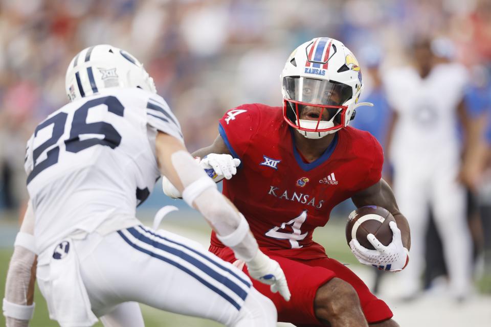 Kansas running back Devin Neal (4) rushes for a first down as BYU safety Ethan Slade (26) defends during the fourth quarter of an NCAA football game on Saturday, Sept. 23, 2023, in Lawrence, Kan. | Colin E. Braley, Associated Press