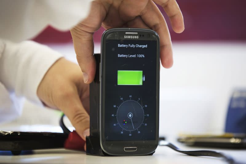 FILE PHOTO: A lab worker disconnects from a charger a mobile phone at headquarters of StoreDot in Tel Aviv