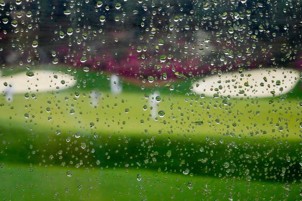 Rain falls on a plexiglass divider in the grandstand on the 13th hole during a practice round for the Masters golf tournament on Wednesday, April 6, 2022, in Augusta, Ga. (AP Photo/Charlie Riedel)