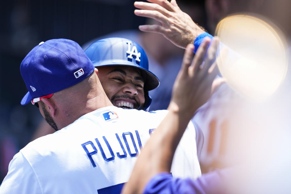 Los Angeles Dodgers' Mookie Betts, center, celebrates with Albert Pujols, left, after hitting a home run during the first inning of a baseball game against the Arizona Diamondbacks Sunday, July 11, 2021, in Los Angeles. (AP Photo/Ashley Landis)