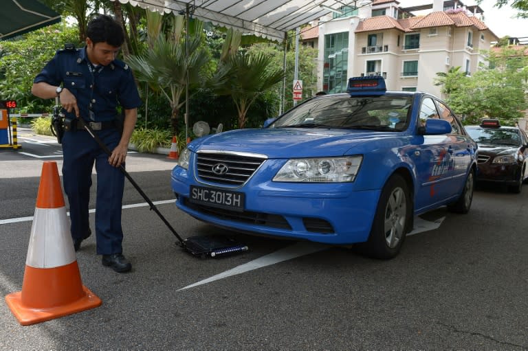 A police officer inspects a car ahead of the meeting between Chinese President Xi Jinping and Taiwan President Ma Ying-jeou, at Shangri-La hotel in Singapore, on November 7, 2015