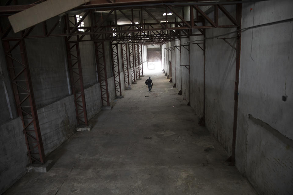 A worker walks through an empty warehouse owned by Marche Titony, in Port-au-Prince, Haiti, Tuesday, Sept. 21, 2021. The warehouse was looted by gangs on June 16th. (AP Photo/Rodrigo Abd)