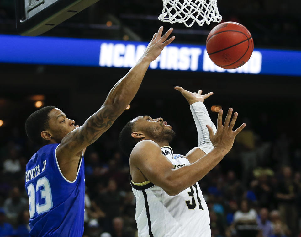 Seton Hall's Shavar Reynolds, left, partially blocks a shot by Wofford's Donovan Theme-Love during the first half of a first-round game in the NCAA men’s college basketball tournament in Jacksonville, Fla., Thursday, March 21, 2019. (AP Photo/Stephen B. Morton)