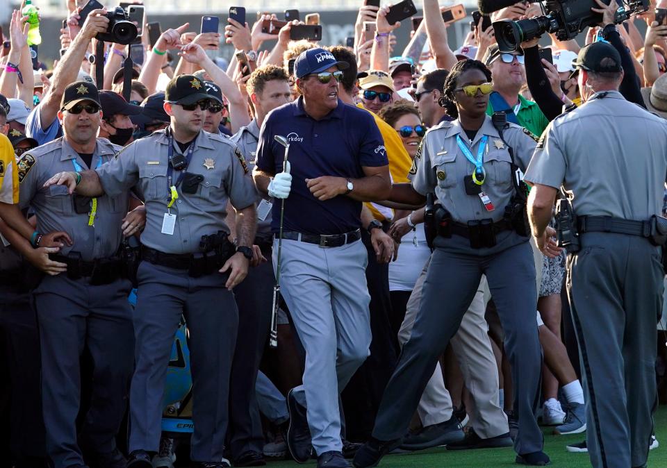 FILE - Phil Mickelson, center, wades through fans on the 18th fairway during the final round at the PGA Championship golf tournament on the Ocean Course, May 23, 2021, in Kiawah Island, S.C. Mickelson's tee shot on the final hole to become at age 50 golf's oldest major champion was one of his special memories. (AP Photo/Matt York, File)