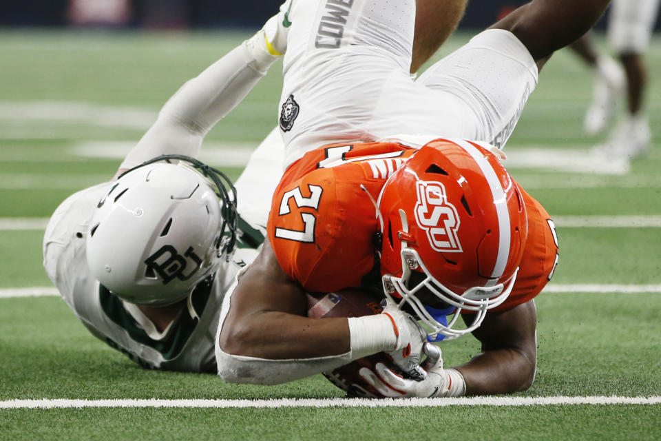 Oklahoma State running back Dezmon Jackson (27) is tackled by Baylor linebacker Dillon Doyle short of the goal line in the second half of an NCAA college football game for the Big 12 Conference championship in Arlington, Texas, Saturday, Dec. 4, 2021. (AP Photo/Tim Heitman)