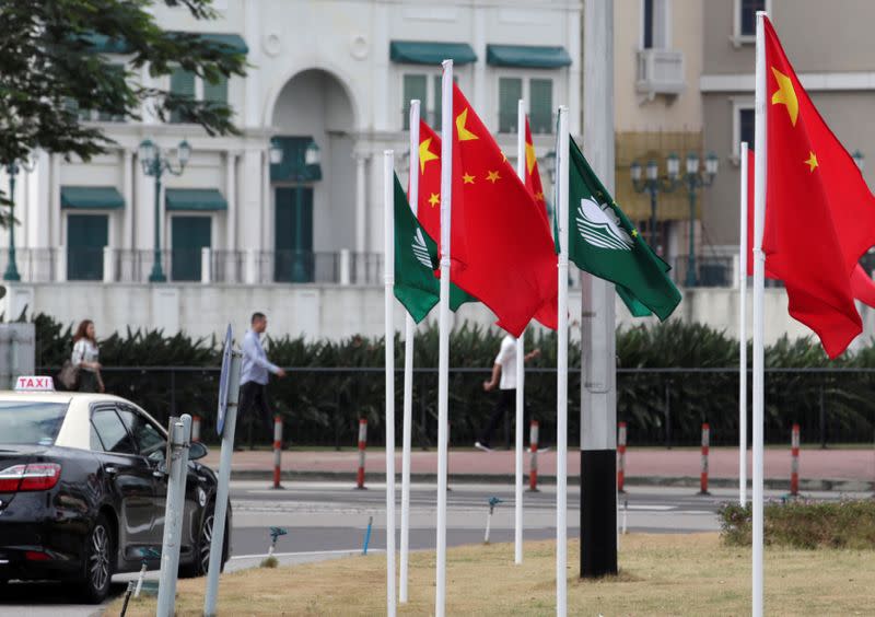 Flags of China and Macau are set up at a traffic ring island in Macau