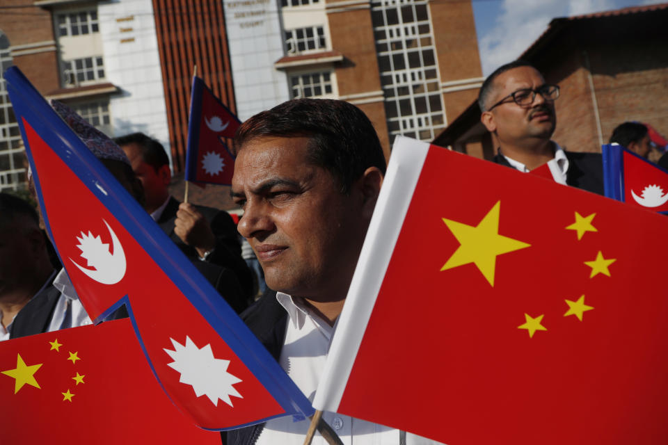 A Nepalese man holds Chinese and Nepalese flag as he waits to welcome Chinese president Xi Jinping in Kathmandu, Nepal, Saturday, Oct 12, 2019. Xi arrived Saturday from New Delhi, where he met with Indian Prime Minister Narendra Modi. He was received by Nepalese President Bidhya Devi Bhandari and Prime Minister K.P. Sharma Oli at the Kathmandu airport. (AP Photo/Niranjan Shrestha)
