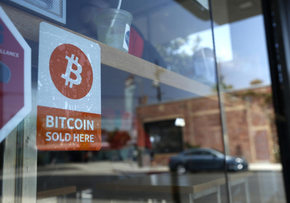 A bitcoin sticker is seen in the window of Locali Conscious Convenience store, in Venice, Los Angeles, California. Photo; Lucy Nicholson/Reuters