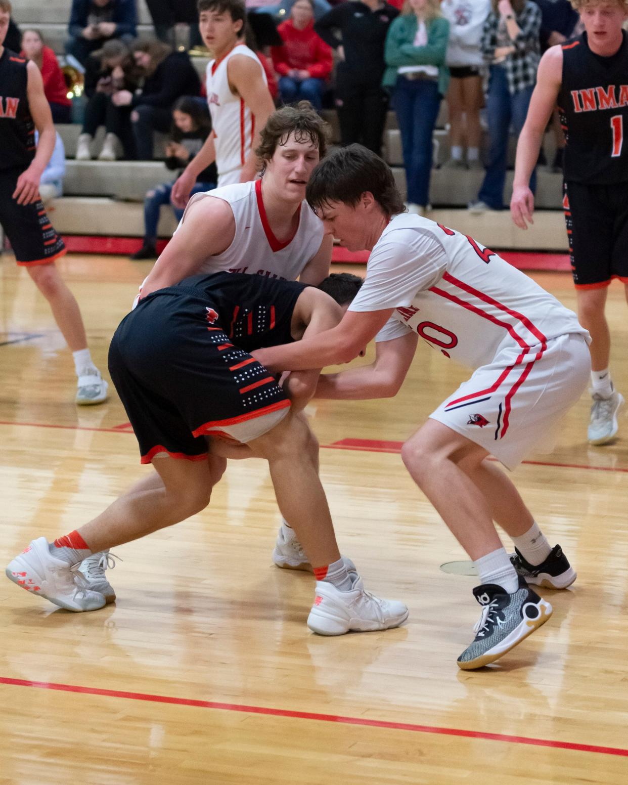 Ell-Saline's Mason Ellerman (20) and Kade Wilson apply defensive pressure late in the Cardinals' home game against Inman on Tuesday. 