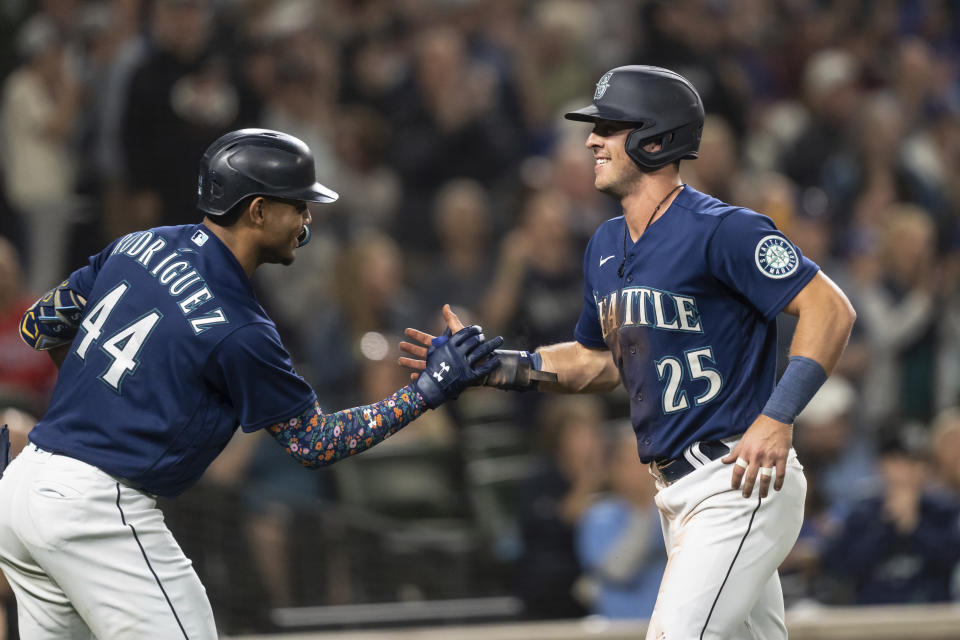 Seattle Mariners' Dylan Moore, right, is congratulated by Julio Rodriguez after scoring a run during the fifth inning of a baseball game against the Detroit Tigers, Monday, Oct. 3, 2022, in Seattle. (AP Photo/Stephen Brashear)