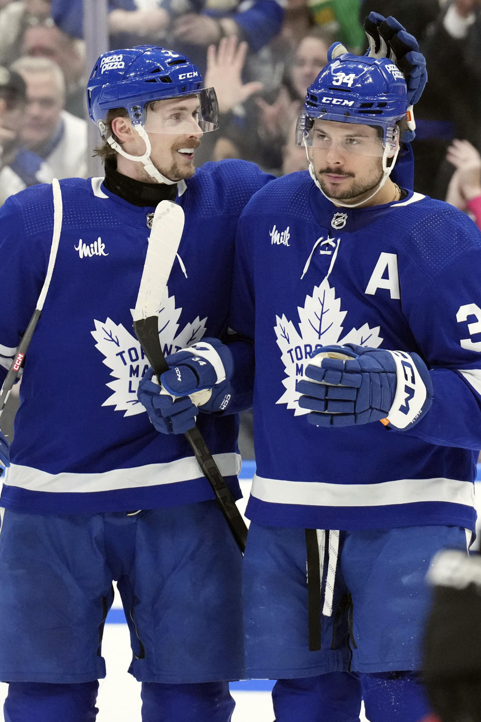 Toronto Maple Leafs' Auston Matthews, right, is congratulated by Simon Benoit after scoring his third goal against the Anaheim Ducks during the second period of an NHL hockey game, Saturday, Feb. 17, 2024 in Toronto. (Chris Young/The Canadian Press via AP)