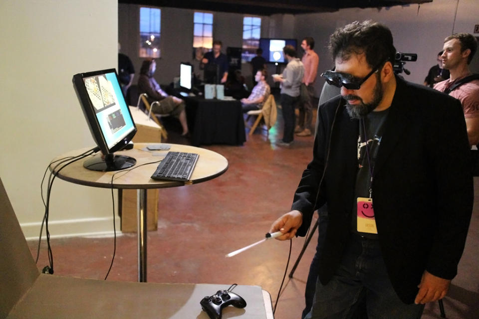 This Sept. 20, 2013 image released by Technical Illusions shows TextFiles.com founder and owner Jason Scott using the CastAR augmented reality 3D glasses in Portland, Ore. Wearable technology such as CastAR was among the topics discussed at the Game Developers Conference Next at the Los Angeles Convention Center on Nov. 5-7, 2013. (AP Photo/Technical Illusions/Jenesee Grey)