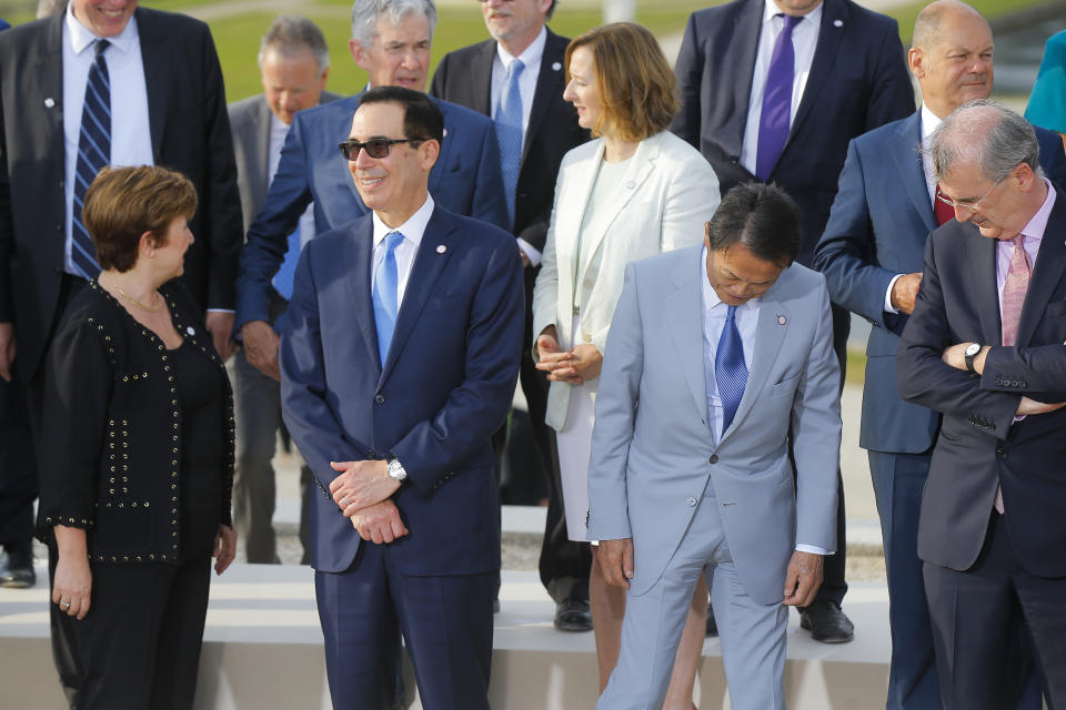 US Treasury Secretary Steve Mnuchin, second left, talks to Chief Executive of the World Bank Kristalina Georgieva, left, next to Japan's Finance Minister Taro Aso, second right, and Bank of France Governor Francois Villeroy de Galhau, right, prior a group photo at the G-7 Finance in Chantilly, north of Paris, on Wednesday, July 17, 2019. The Group of Seven rich democracies' top finance officials gathered Wednesday at a chateau near Paris in search of common ground on the threats posed by digital currencies. (AP Photo/Michel Euler)